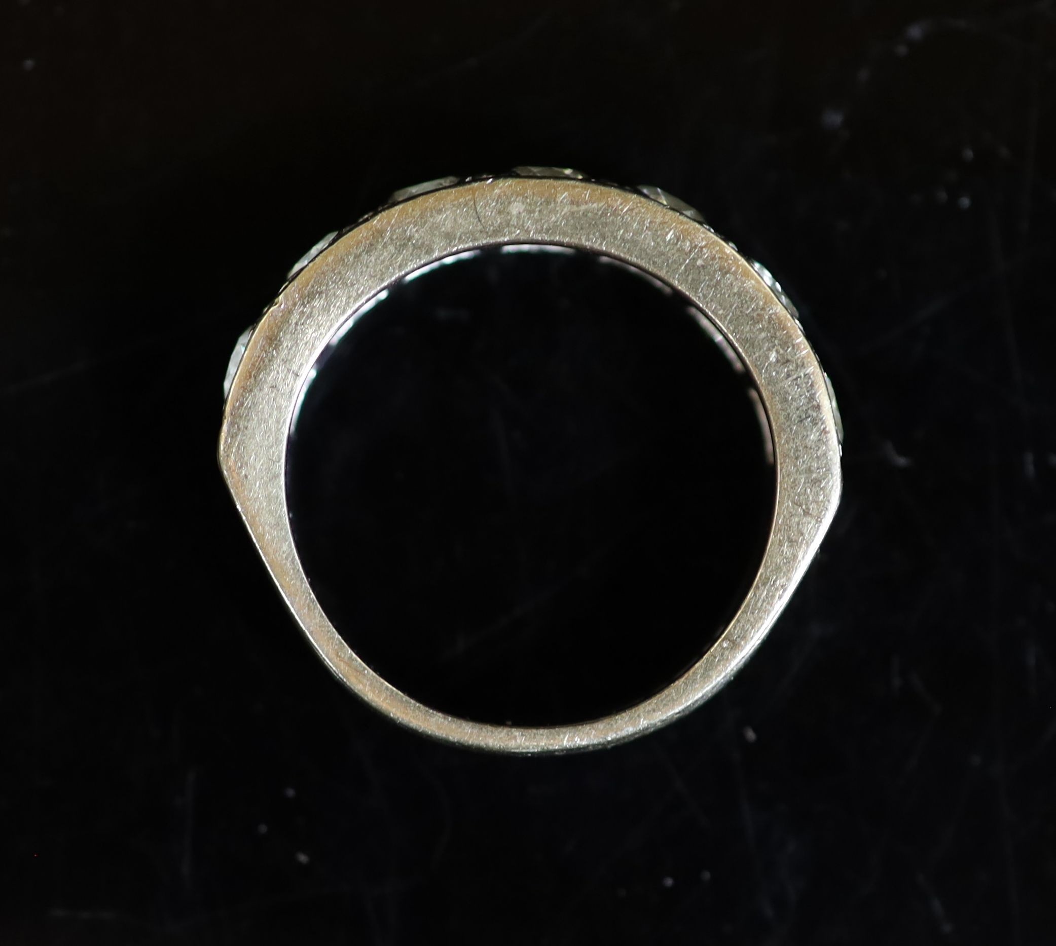 A modern white gold and channel set seven stone diamond half hoop ring